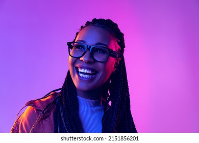 Smiling. Portrait of female fashion model in cotton shirt isolated on purple background in neon light. Concept of beauty, art, fashion, youth, sales and ads. Pretty woman laughing