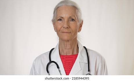 Smiling Portrait Of Mature Woman Doctor Talking Over Video Chat To Patient On Tele Health Consultation.