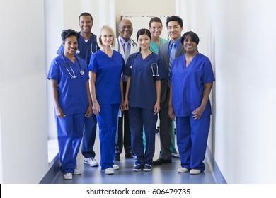 Smiling Portrait Multi Ethnic Team In Uniform Providing Healthcare Treatment And Patient Diagnosis In Modern Medical Facility