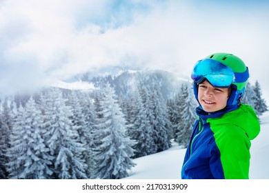 Smiling Portrait Of A Young Boy In Ski Helmet And Mask Smile Standing Over Forest After Heavy Snowfall