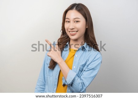 Smiling positive, attractive asian young woman hand pointing away, wearing casual, portrait girl of beautiful brunette hair. Cheerful expression face happy standing isolated on white background.