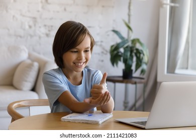 Smiling positive teen pupil boy with hearing disability studying online from home, talking on video on laptop, speaking, using sign deaf language, showing gestures at screen. Childhood, education - Powered by Shutterstock