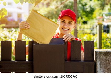 Smiling Postman Mail Carrier Inserting Envelope Into Mailbox