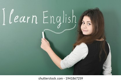 Smiling Pre-adolescent Child Writes In Chalk 