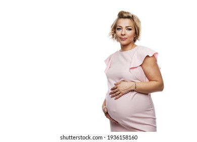 Smiling pregnant woman in a delicate dress. Baby care and health. Isolated on a white background. Space for text.