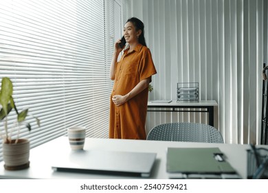 Smiling Pregnant Woman Talking on Phone in Office - Powered by Shutterstock