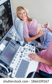 Smiling pregnant woman undergoing ultrasound in the hospital