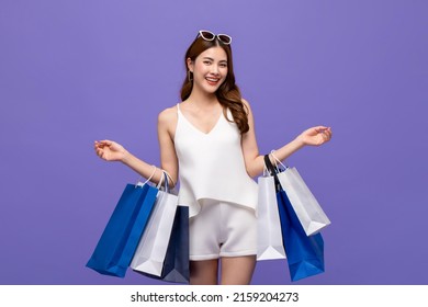 Smiling Pretty Asian Woman Carrying Shopping Bags In Purple Color Studio Background