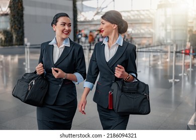 Smiling Pretty Flight Attendants With Bags Talking In The Terminal