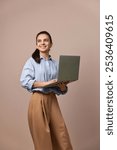 smiling pretty freelancer business woman in blue shirt using laptop for work, e-learning, e-banking or online shopping on beige background