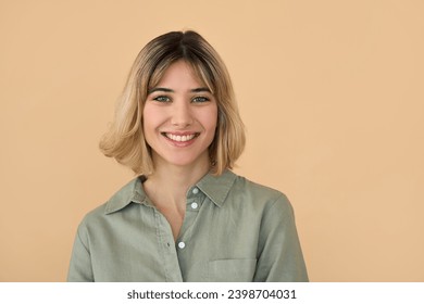 Smiling pretty gen z blonde young woman, cute happy 20s european student girl with short blond hair wearing khaki shirt looking at camera standing isolated on beige background. Close up portrait. - Powered by Shutterstock