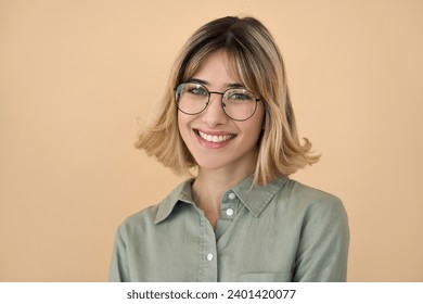 Smiling pretty gen z blonde young woman, happy college student girl with short blond hair wearing glasses looking at camera standing isolated on beige background. Close up headshot portrait. - Powered by Shutterstock