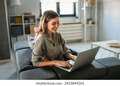 Smiling pretty woman using laptop for work freelance social media or relaxation. - Powered by Shutterstock