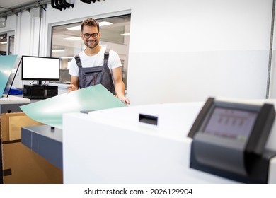 Smiling Print Worker Operating Computer To Plate Machine In Print Shop.