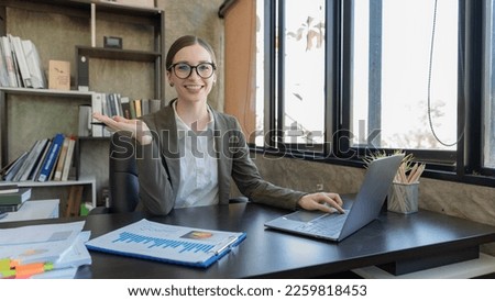 Smiling professional businesswoman working with a laptop in an office.