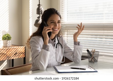 Smiling Professional Female Doctor Wearing Uniform Talking On Phone, Physician Consulting Patient, Explaining, Discussing Medical Checkup Result Or Treatment, Good News, Giving Recommendations