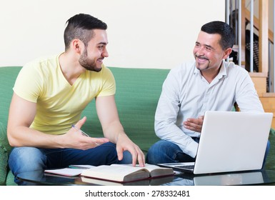 Smiling professor giving private lesson to happy student at home