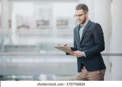 Smiling Professor Grading Student Papers Between Classes Using A Clipboard