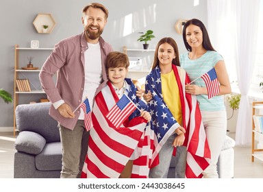 Smiling proud family wrapped in USA flags celebrating independence day at home. Happy family of four wrapped in American flags and exude patriotic spirit, celebrating unity and national pride. - Powered by Shutterstock