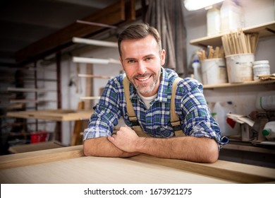 Smiling and proud mature carpenter in his carpentry workshop - Powered by Shutterstock