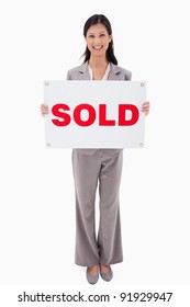 Smiling Real Estate Agent With Sold Sign Against A White Background