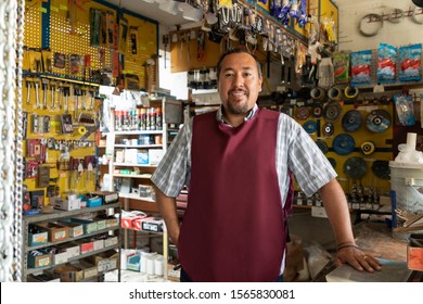 Smiling Real Worker Attending A Hardware Store. Interior Detail