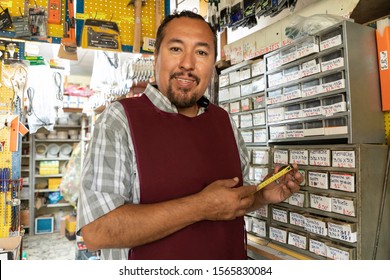 Smiling Real Worker Attending A Hardware Store. Interior Detail