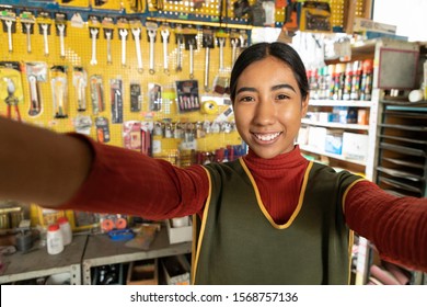 Smiling Real Worker Taking A Selfie A Hardware Store. Interior Detail