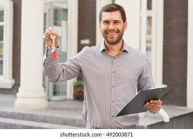 Smiling Realtor Standing Outside Modern House