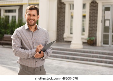 Smiling Realtor Standing Outside Modern House