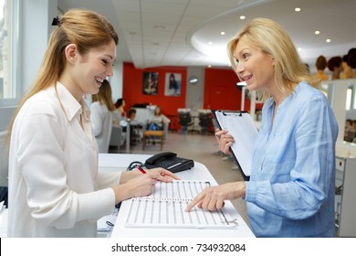 Smiling Receptionist And Manager At Beauty Salon Reception