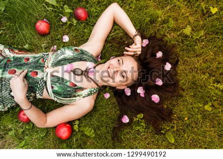smiling red-haired alternative girl with shaved walks in a Sunny Apple orchard on a Sunny summer day