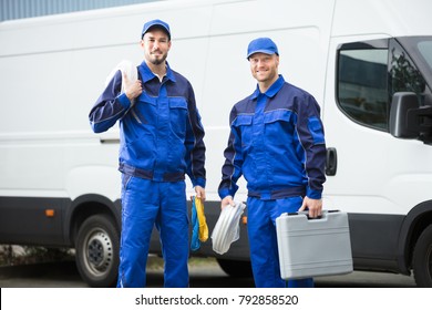 Smiling Repairman With Toolbox And Cable Standing In Front Of Vehicle - Powered by Shutterstock