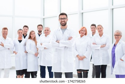 smiling research supervisor standing in front of his team.