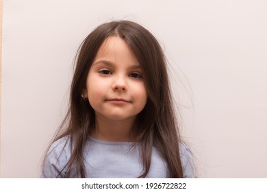 Smiling sad mysterious white little girl with closed eyes on white background