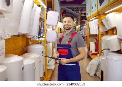 Smiling salesman or assistant in uniform work in building hypermarket with good restock. Portrait of happy male consultant check products in household or construction store. Retail concept.