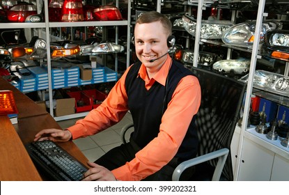 Smiling Salesman Auto Parts Store With A Computer