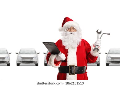 Smiling Santa Claus in a car showroom holding a clipboard and car repair tools isolated on white background - Powered by Shutterstock