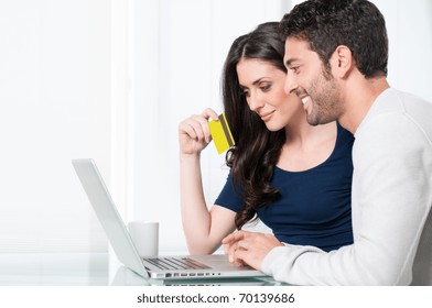 Smiling Satisfied Couple Buying Online With Credit Card At Home