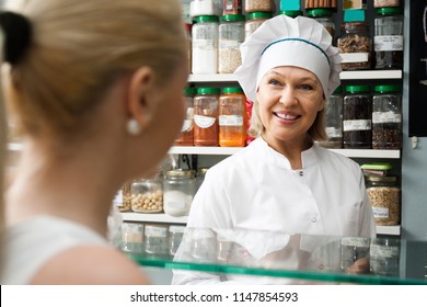 Smiling Satisfied Mature Woman Buying Different Nuts In Local Supermarket