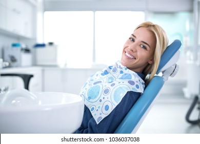 Smiling and satisfied patient in a dental office after treatment - Shutterstock ID 1036037038
