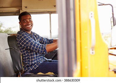 Smiling school bus driver sitting in bus