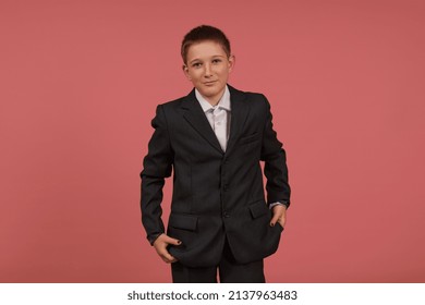 Smiling Schoolboy In A Black Suit With Painted Nails Stands On A Pink Background