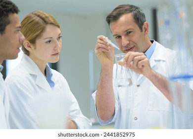 smiling scientist teacher holding dna model in laboratory - Powered by Shutterstock