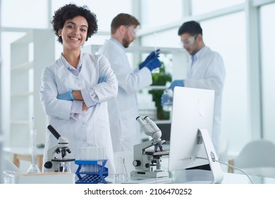 Smiling scientists looking at camera arms crossed in laboratory - Shutterstock ID 2106470252