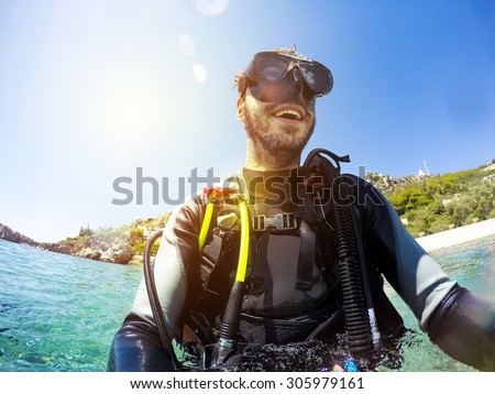 Smiling scuba diver portrait at the sea shore. Diving goggles on.