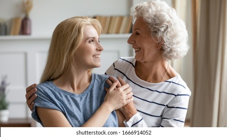 Smiling senior 60s mother and adult millennial daughter hug embrace enjoy family home weekend together, happy loving mature mom and grownup girl child cuddle, having close tender moment - Shutterstock ID 1666914052