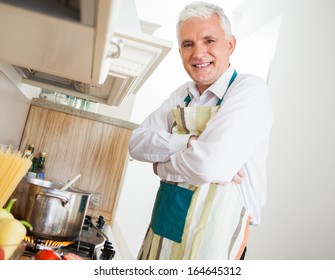 Smiling Senior Caucasian Man Cooking At Home.