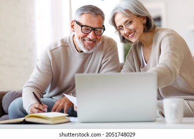 Smiling Senior Couple Calculate Expenses Or Planning Budget Together, Reading Notification Letter With Good News From Bank , Retired Family Husband And Wife Paying Bills Online On Laptop