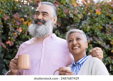 Smiling senior couple enjoying coffee together outdoors, embracing and looking away. Seniors, companionship, retirement, lifestyle, happiness, togetherness - Powered by Shutterstock